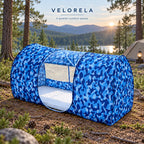 Blue camouflage Single Door mosquito shelter with central side entrance at a lakeside campsite