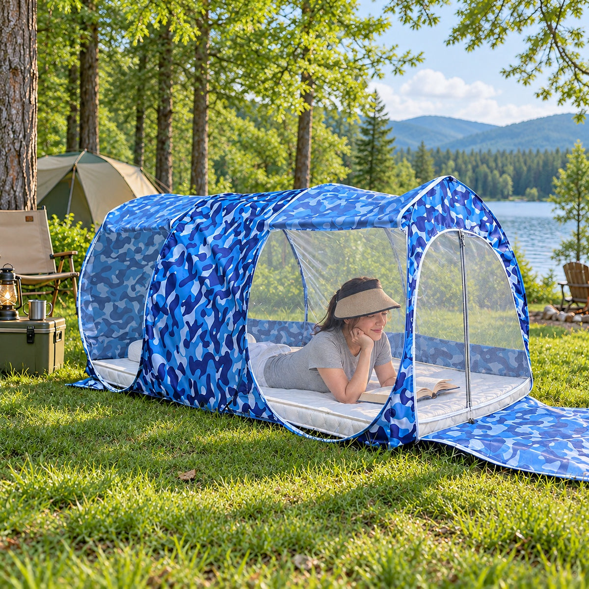 Woman reclining with a book inside the Three-Opening camouflage mosquito shelter at a green campsite