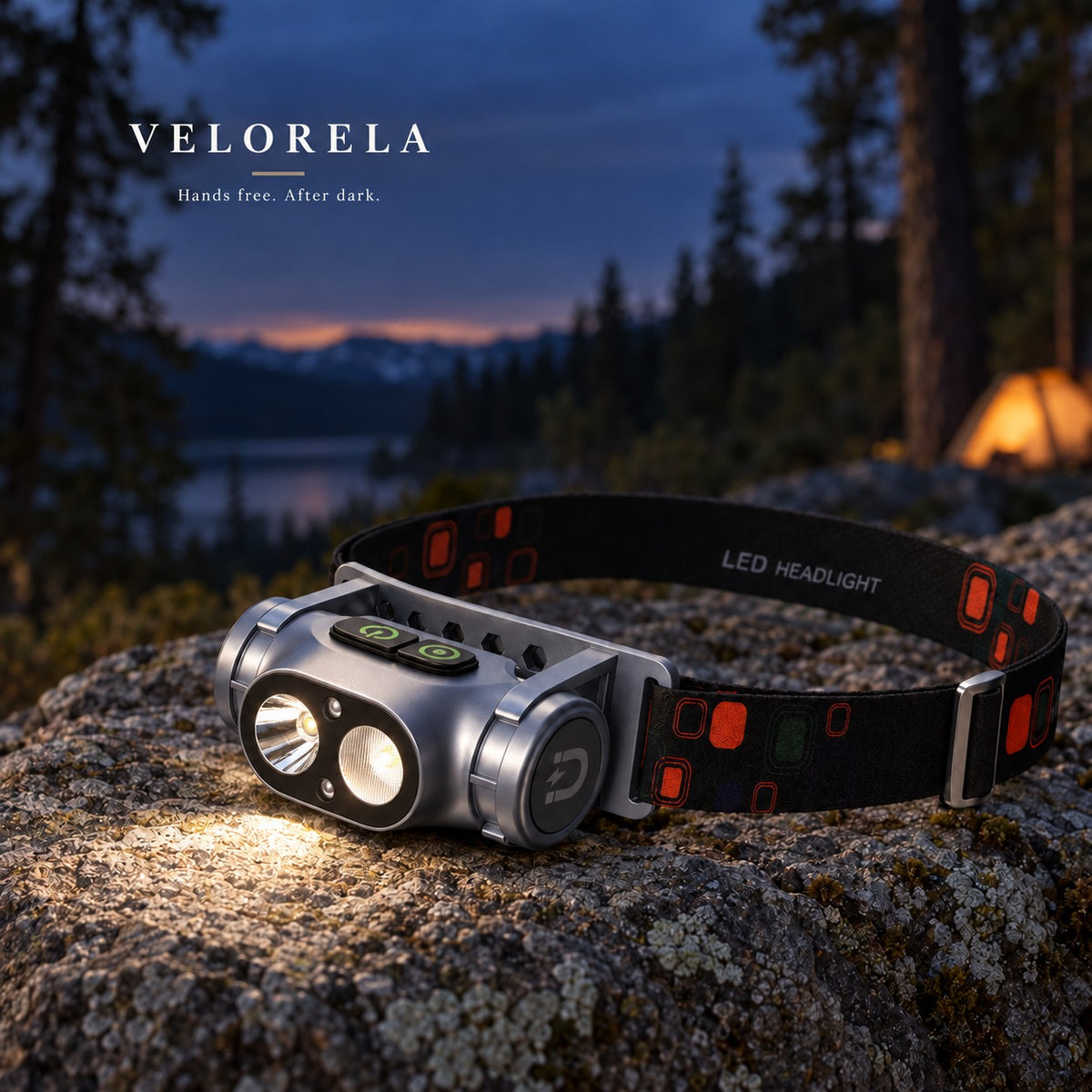 Gray dual-beam rechargeable headlamp at a forest campsite after dusk.