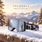 Velorela Silver / Temple magnetic snow goggles with the matching black frame and printed strap in an alpine snow scene
