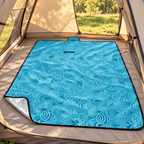 Ocean Shells fleece picnic blanket laid inside a tent over its existing groundsheet, with silver backing visible