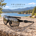 Velorela Black photochromic sports sunglasses resting entirely on a lakeside granite rock